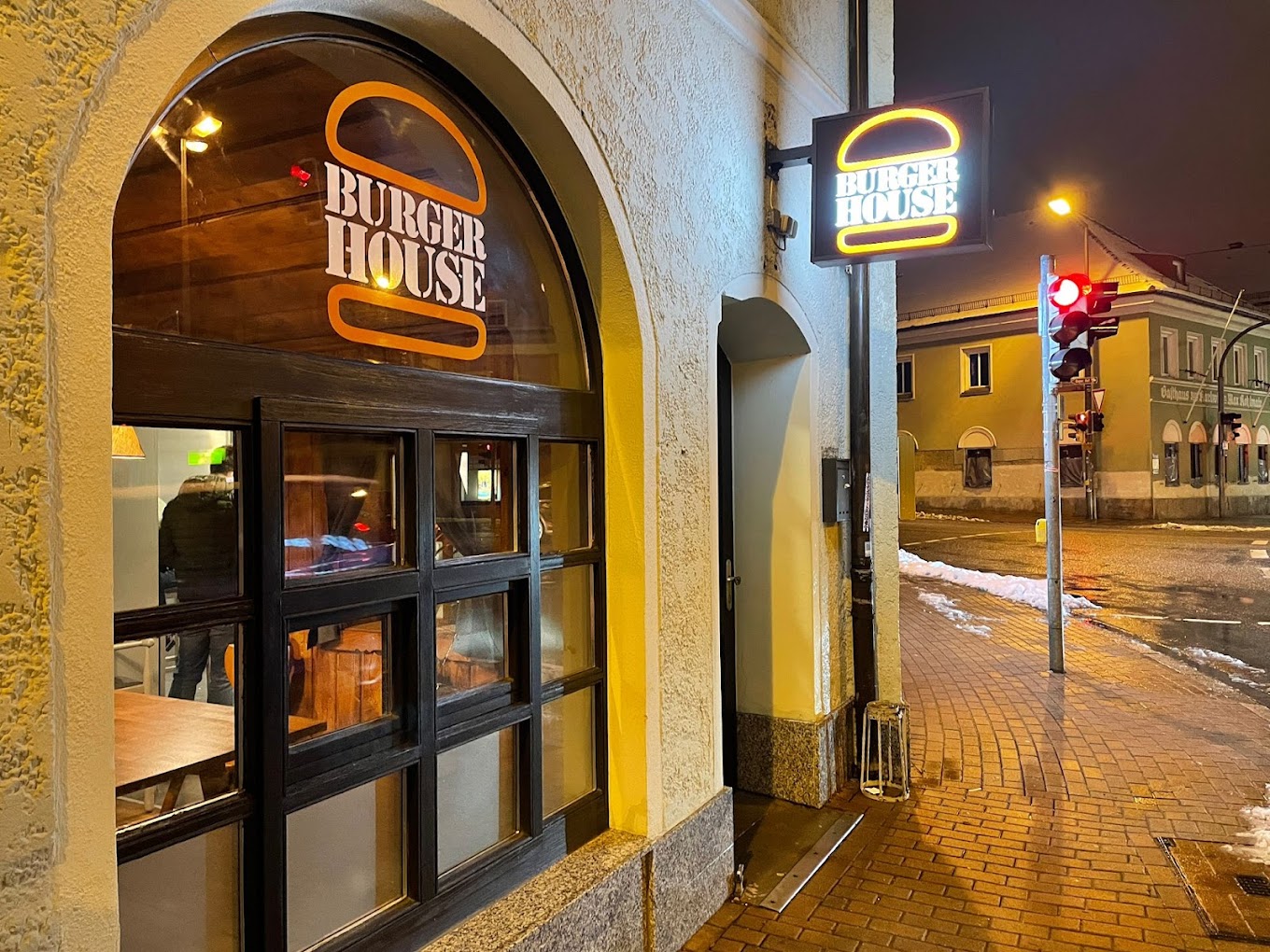 Außenansicht auf das Restaurand "Burger House" mit Fensterfront und dem "Burger House" Logo.