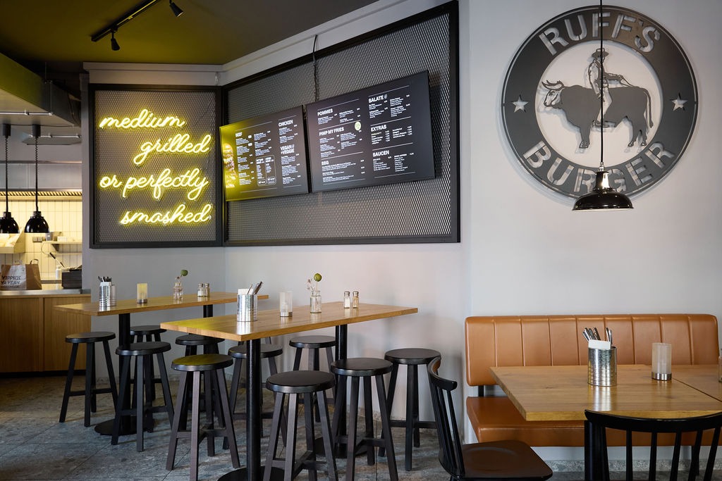 Innenbereich eines Ruff's Burger Restaurant mit Tischen und Barhockern