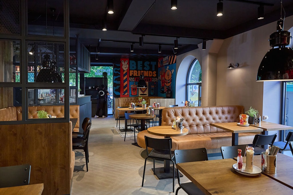 Drei Personen essen an einem Tisch Burger